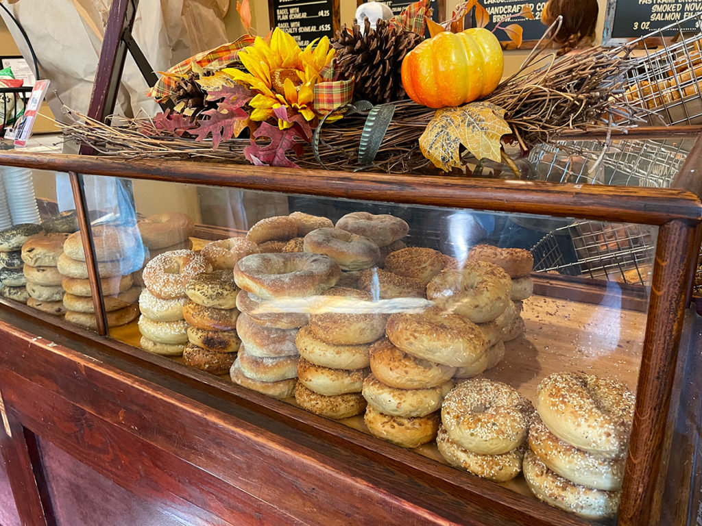Bagels inside a display case with October decorations on top.